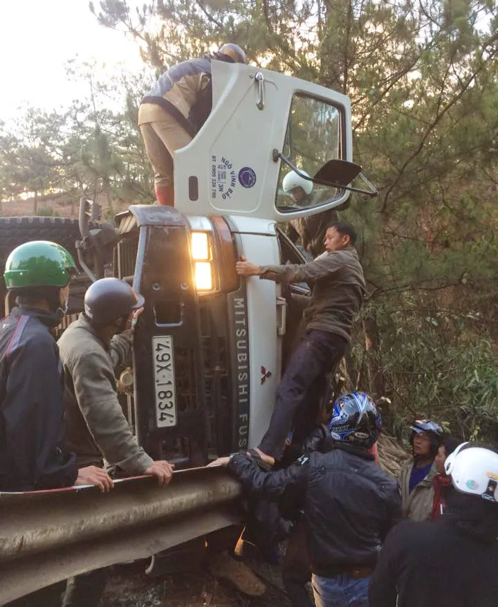 Xe tải lật ngang, tài xế mắc kẹt trong cabin ảnh 1