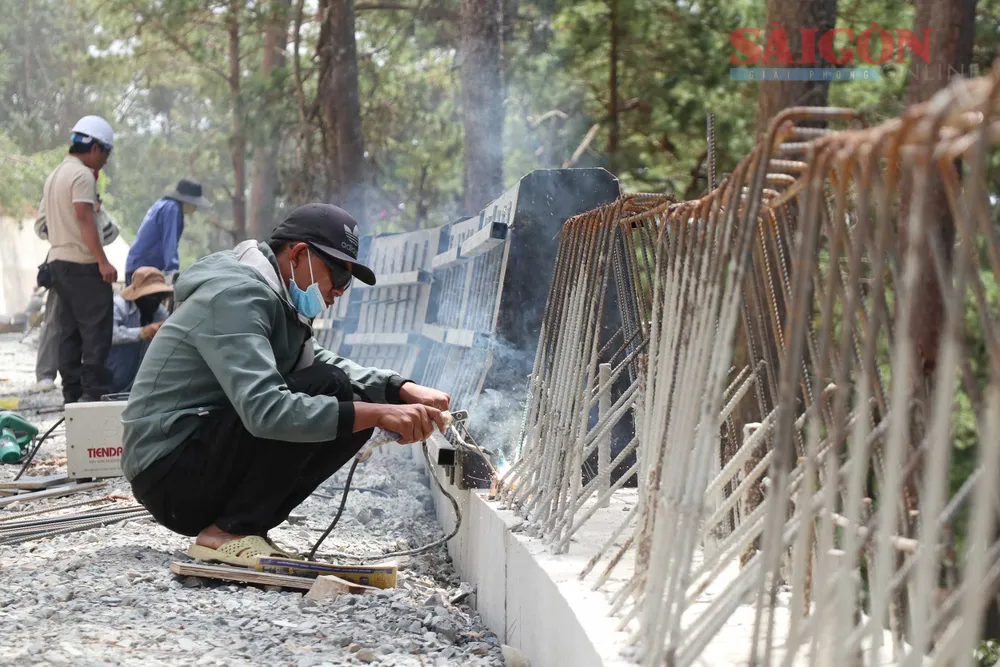 Các công nhân tranh thủ thời tiết khô ráo để đẩy nhanh tiến độ. Ảnh: ĐOÀN KIÊN