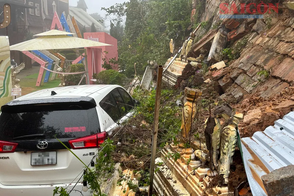 Bờ taluy sạt đè lên ô tô tại hiện trường. Ảnh: ĐOÀN KIÊN