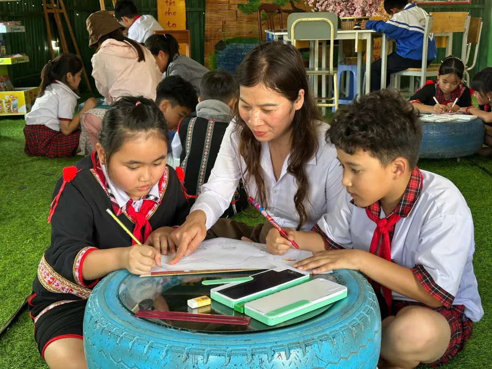 Bà Hồ Thị Thùy Vân, Hiệu trưởng trường Tiểu học Kim Đồng hướng dẫn học sinh vẽ tranh cổ động.jpg