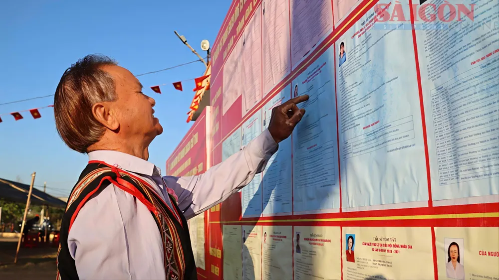 Già làng Rơ Châm Ơm (làng C, xã Gào) xem thông tin các đại biểu trước khi quyết định bỏ phiếu. Ảnh HỮU PHÚC.jpg