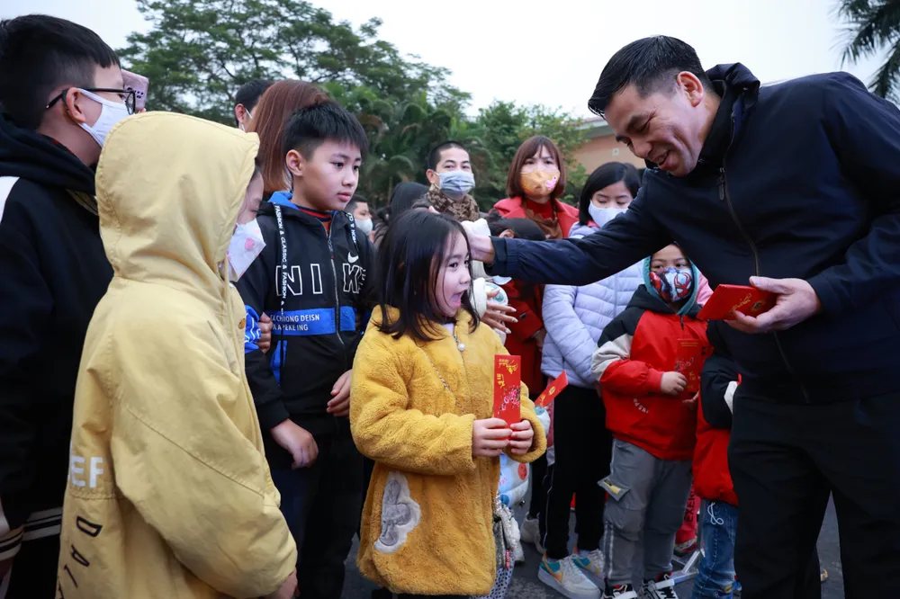 Cán bộ công đoàn của LĐLĐ TP Hà Nội lì xì cho các cháu là con em của các công nhân chuẩn bị lên xe về quê đón tết. Ảnh: HẢI NGUYỄN