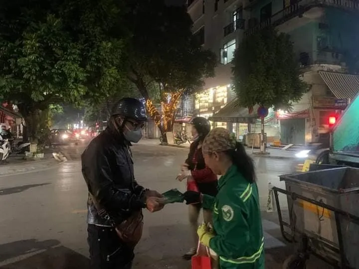 Các tình nguyện viên của nhóm thiện nguyện Hải Đăng và Lá Bối ở Hải Phòng tặng quà và lì xì cho những công nhân quét rác đêm giao thừa Tết Quý Mão 2023