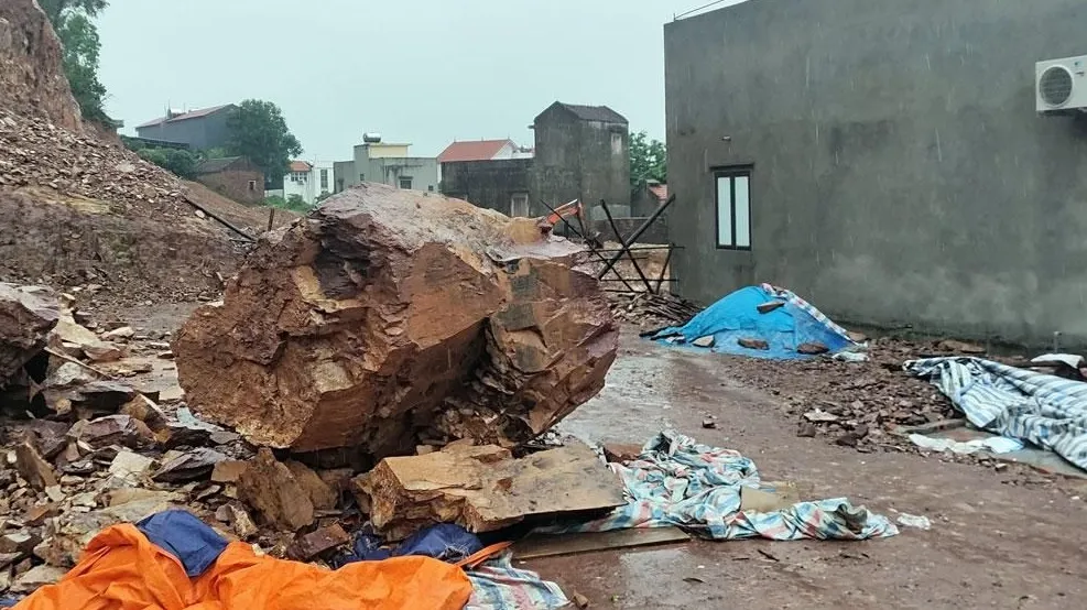 Tảng đá lớn từ núi sau nhà sạt xuống khu vực đang chuẩn bị làm đám cưới tại thôn Trúc Tay (Việt Yên - Bắc Giang) sáng 5-8. Ảnh: SỸ QUYẾT