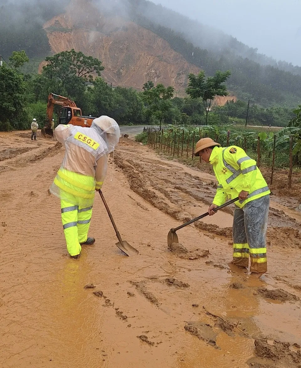 CSGT ở tỉnh Lai Châu đội mưa dọn bùn để thông đường. Ảnh: Công an tỉnh Lai Châu