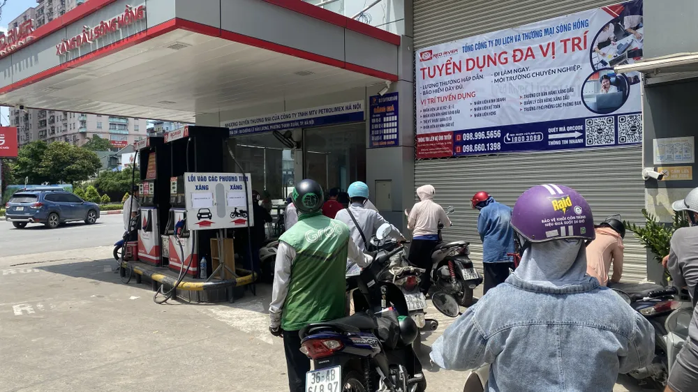 Người dân Hà Nội chờ đổ xăng E10 trên đường Lê Văn Lương trưa 28-5. Ảnh: PHÚC HẬU