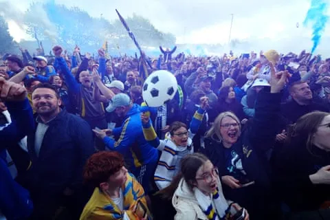 Người hâm mộ Leeds United ăn mừng việc thăng hạng Premier League bên ngoài sân Elland Road vào tối thứ Hai. Ảnh: Mike Egerton/PA