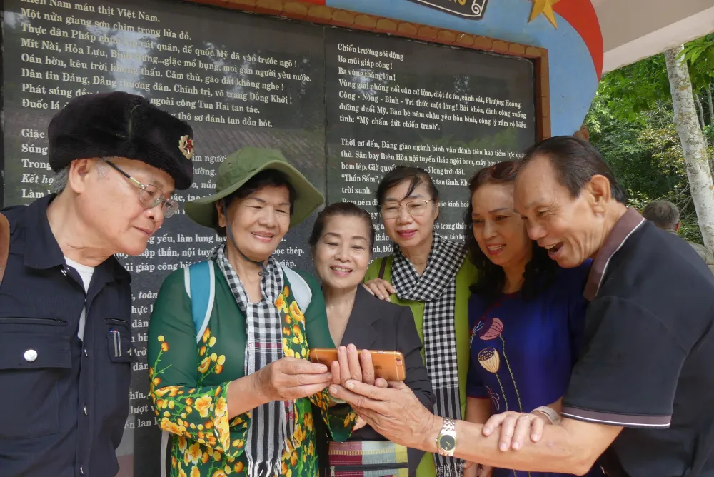 Các đại biểu vui mừng gặp lại nhau, xem ảnh chụp kỷ niệm trong buổi họp mặt