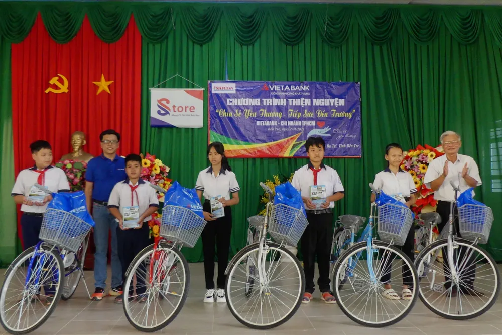Đại diện Ngân hàng TMCP Việt Á - Chi nhánh TPHCM và Hội Khuyến học huyện Ba Tri trao quà cho học sinh nghèo. Ảnh: KHẢ HÂN