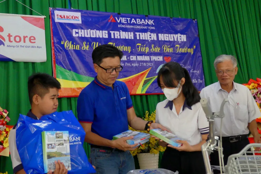 Ông Nguyễn Hữu Thanh Sơn, Phó Giám đốc Ngân hàng TMCP Việt Á - Chi nhánh TPHCM trao quà cho học sinh tại chương trình. Ảnh: KHẢ HÂN
