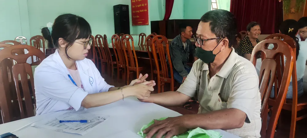 Bác sĩ kiểm tra nguyên nhân đau bàn tay của một người dân. Ảnh: KHẢ HÂN