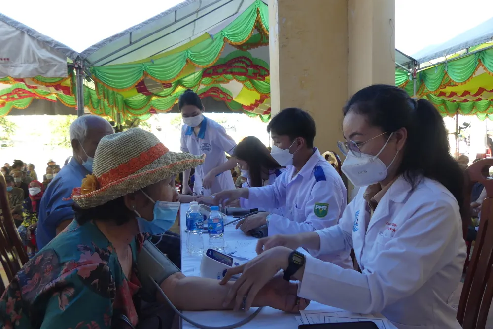 Người dân được đo huyết áp trước khi được các bác sĩ thăm khám. Ảnh: KHẢ HÂN