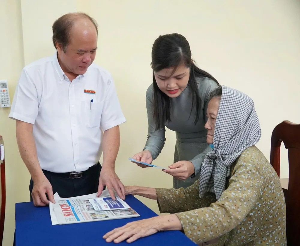 Bà Đinh Thị Phương Thảo, Phó Chủ tịch UBND xã Hưng Long, cùng ông Vũ Anh Tuấn, Phó Giám đốc Thường trực Trung tâm Dịch vụ Truyền thông - Sự kiện Báo Sài Gòn Giải Phóng, trực tiếp trao quà tại xã Hưng Long. Ảnh: VIỆT NGA