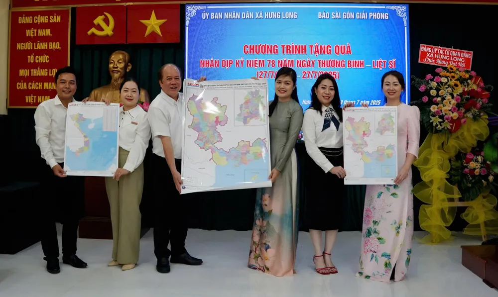 Đại diện Báo Sài Gòn Giải Phóng trao tặng Bản đồ đơn vị Hành chính cấp tỉnh Việt Nam và Bản đồ Hành chính cấp xã của TPHCM năm 2025 đến Đảng ủy xã Hưng Long. Ảnh: VIỆT NGA