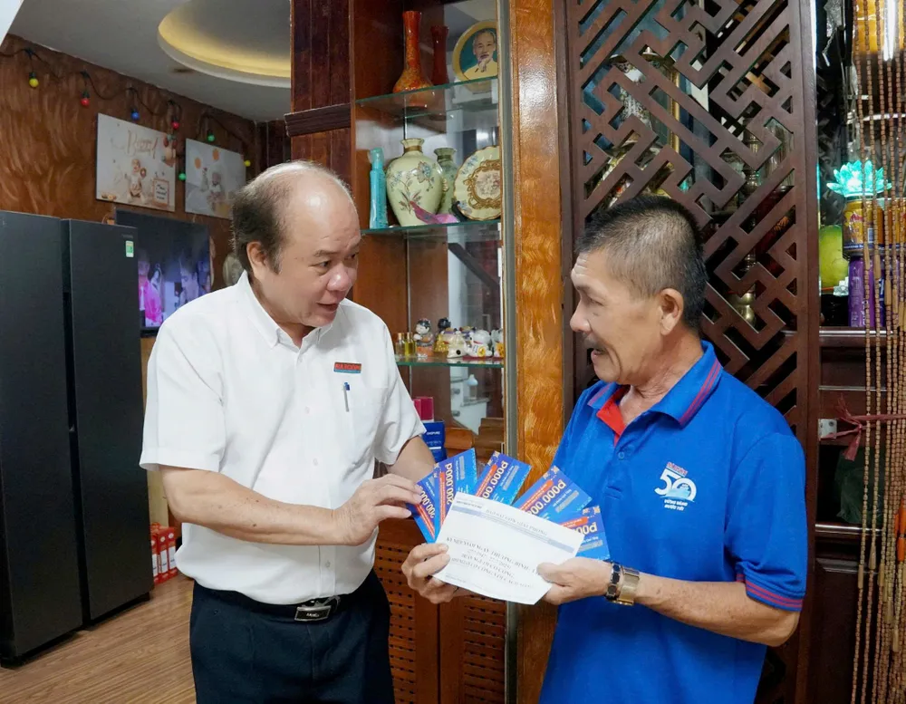 Ông Vũ Anh Tuấn, Phó Giám đốc Thường trực Trung tâm Dịch vụ Truyền thông - Sự kiện Báo Sài Gòn Giải Phóng, thăm hỏi và tặng quà gia đình liệt sĩ Nguyễn Ánh Hoàng tại Phường Đông Hưng Thuận. Ảnh: VIỆT NGA