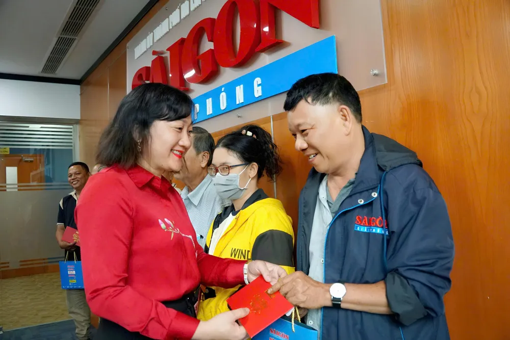 Bà Bùi Thị Hồng Sương, Phó Tổng Biên tập Báo Sài Gòn Giải Phóng trao quà cho cộng tác viên phát hành của báo. Ảnh: VIỆT NGA