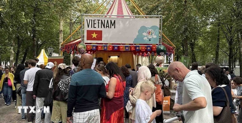 游客排队品尝“We love Phở”展位的牛肉粉。