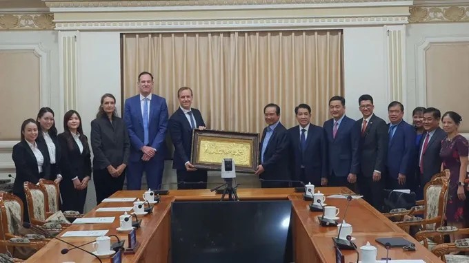 胡志明市人委会主席阮文得向荷兰企业领导赠送纪念品。 