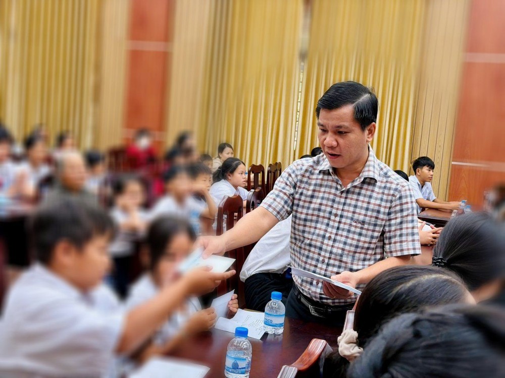 濠庄乡党委书记潘克维向贫困儿童赠送春节礼物。