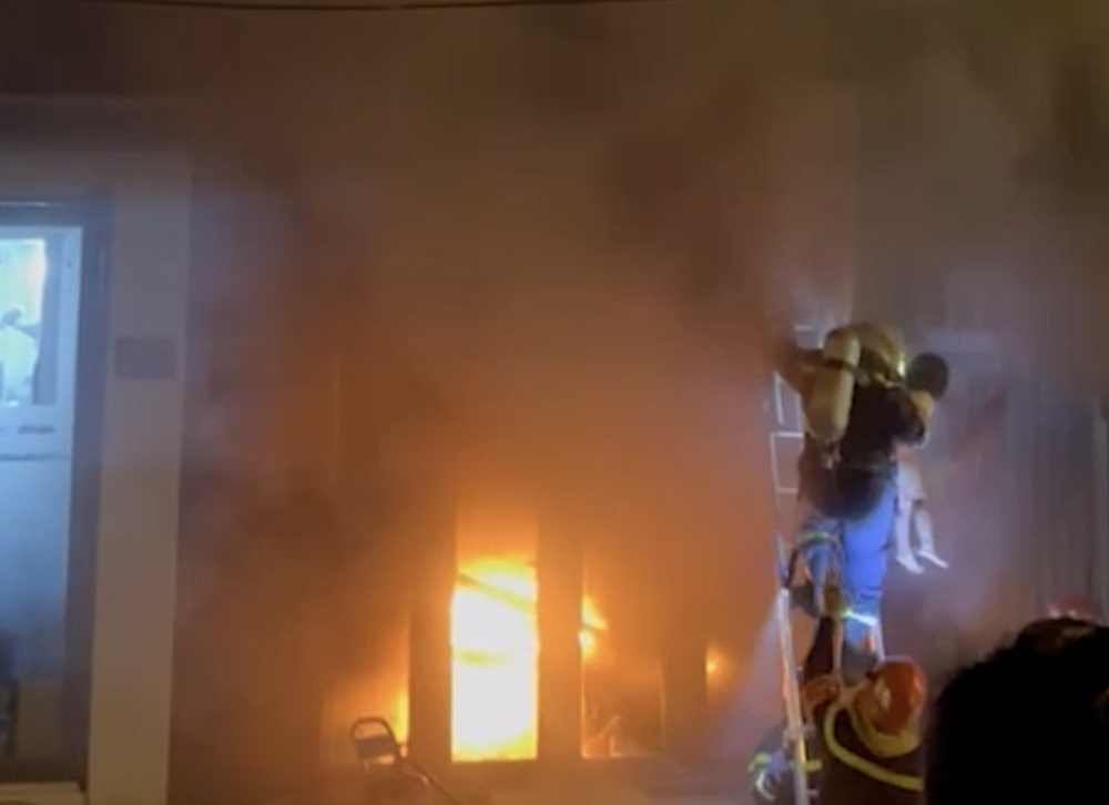 警察在熊熊燃烧、浓烟弥漫的房屋中救出4人。 