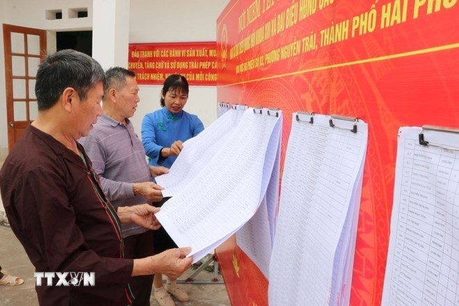 海防市阮廌坊居民查看选民名单。