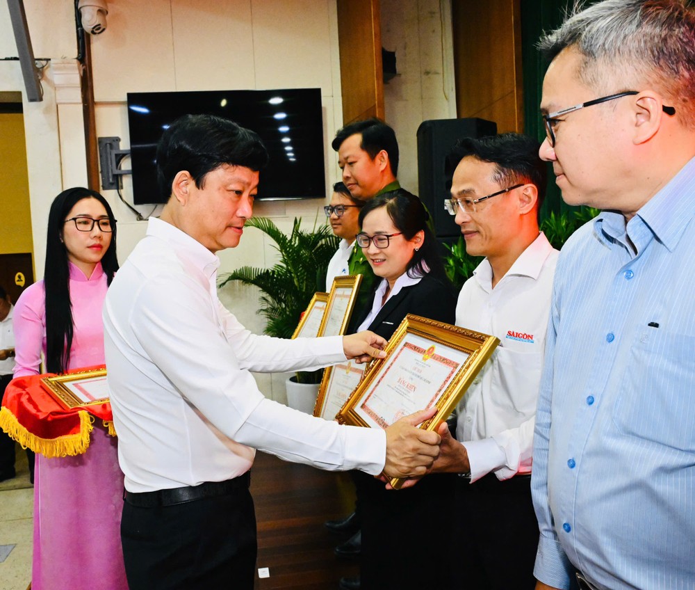 胡志明市人民议会主席武文明向在选举工作中取得出色成绩的《西贡解放报》颁发胡志明市人委会主席奖状。