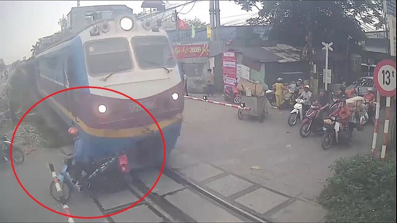 摩托车司机在列车驶来时故意穿越铁路。