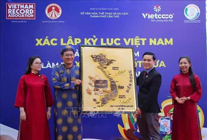 制作单位代表向芹苴市文体与旅游厅赠送“以椰子制作的越南地图”画作。 