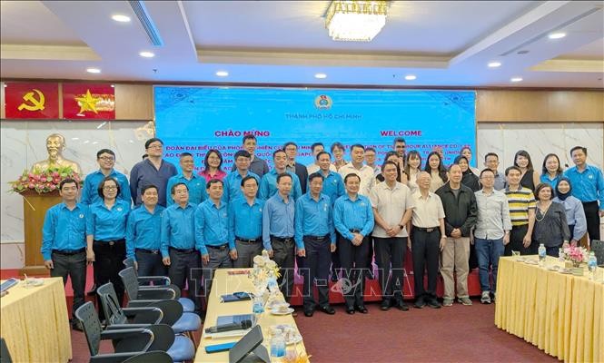 胡志明市劳动联团与新加坡全国职工总会（NTUC）代表们在会议上合影留念。