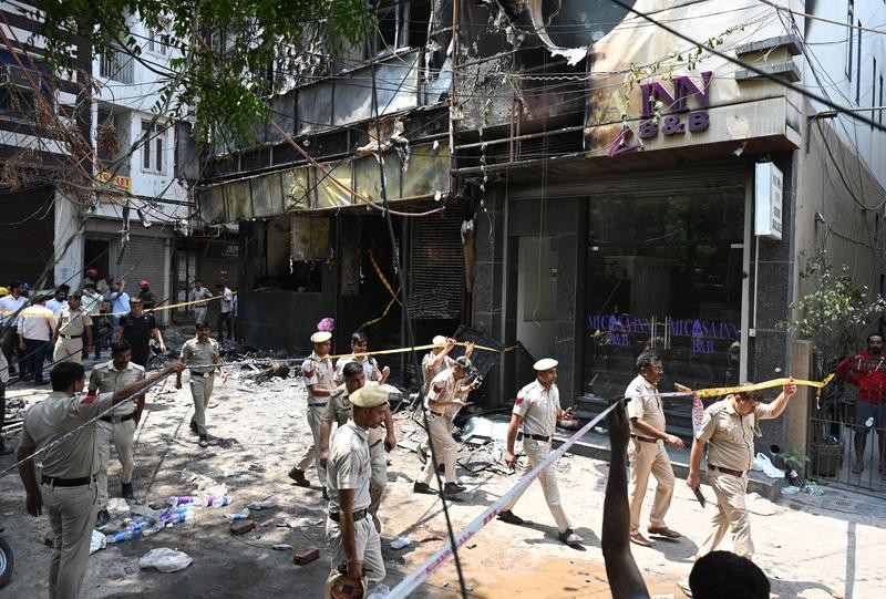 图： 6月3日，在印度新德里，警察和相关工作人员在火灾事故现场调查。 