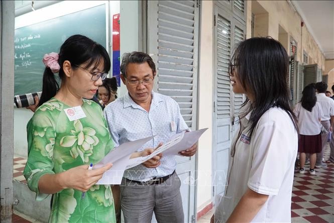 在黎鸿峰高中专校考点，监考干部在进入考室前检查考生信息。