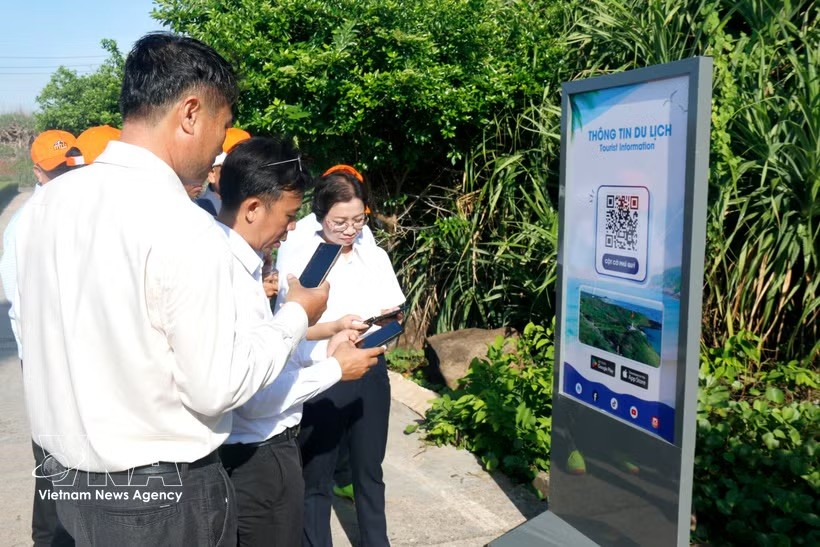 林同省游客在富贵特区主权旗台景点扫描二维码，快速获取旅游信息。