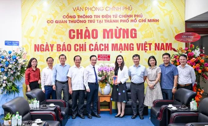 胡志明市市委副书记邓明通向《政府电子报》南方代办处赠送鲜花祝贺。