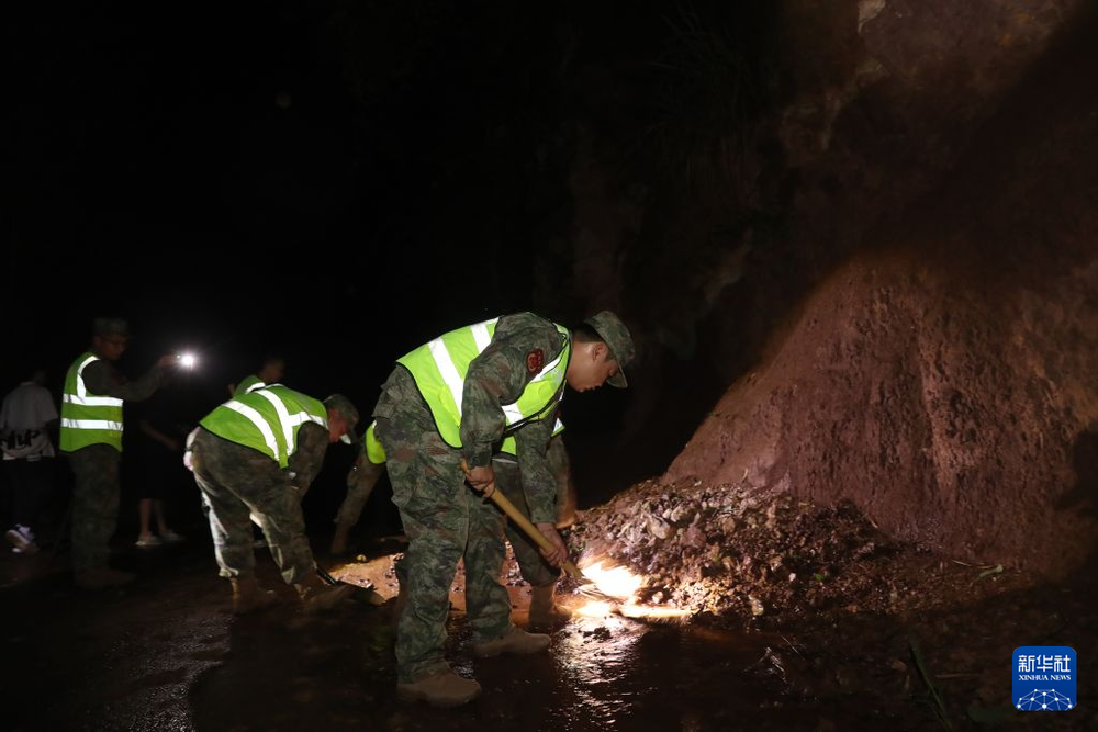 6月29日凌晨，四川省宜宾市高县沙河镇上龙村，民兵在清理道路上的落石。新华社