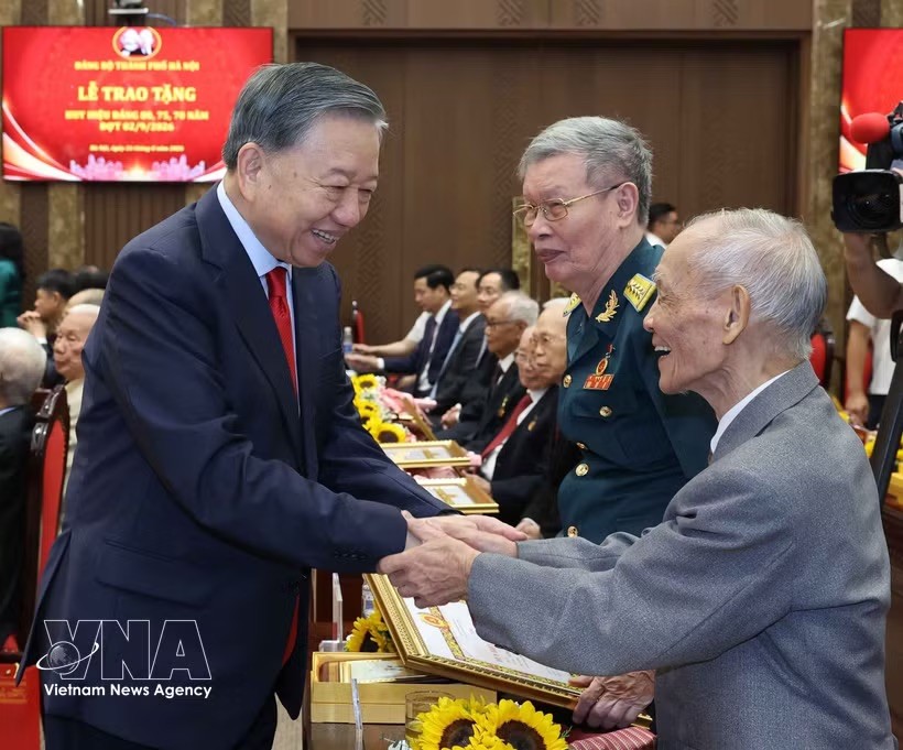 党中央总书记、国家主席苏林和获得党龄纪念章的党员握手。