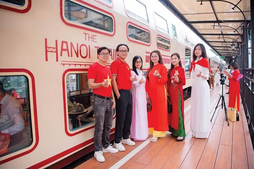 国旗的红色与带有越南标志的服饰为“河内五城门”列车的体验之旅增添色彩。图自《投资报》