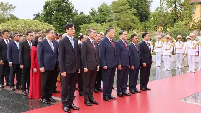 10月5日上午，在第十四届党中央执委会第四次会议开幕前，党中央总书记、国家主席苏林与党政领导及各位代表在河内市北山街英雄烈士纪念碑敬献花圈。图：光福