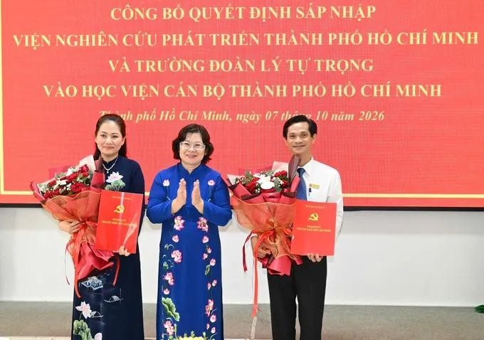 胡志明市市委副书记文氏白雪向胡志明市干部学院院长、副院长颁授决定。图：越勇