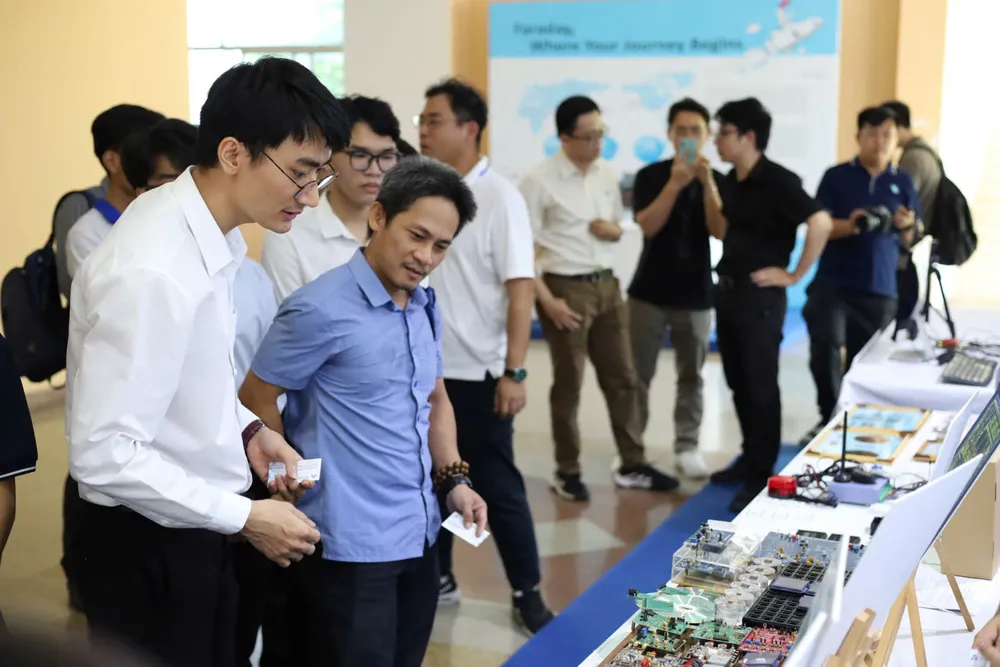 Các đại biểu tìm hiểu sản phẩm vi mạch của Trường ĐH Bách khoa (ĐHQG TPHCM) giới thiệu tại triển lãm.jpg