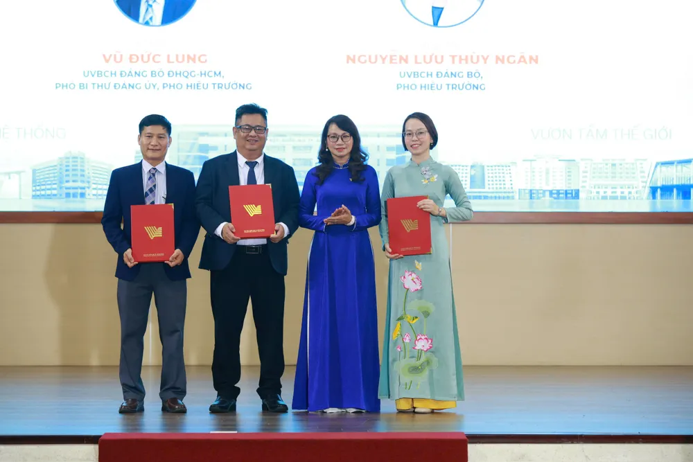 Giám đốc ĐHQG TPHCM trao quyết định cho Ban Giám hiệu Trường ĐH Công nghệ Thông tin - Ảnh: THANH HÙNG