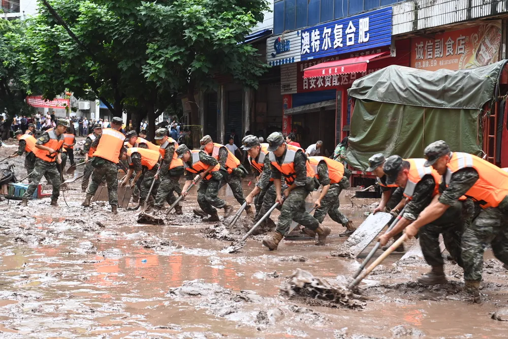 Dọn bùn lũ tại Trùng Khánh. Ảnh: China Daily Dọn bùn lũ tại Trùng Khánh. Ảnh: China Daily