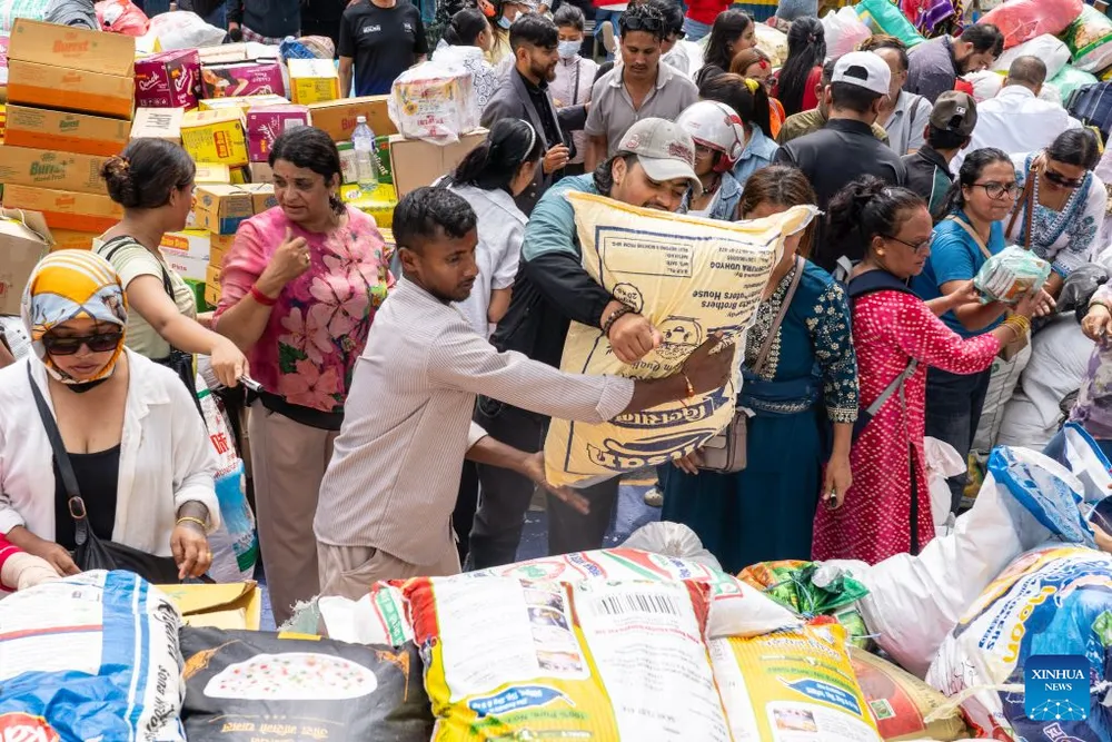 Tình nguyện viên ở Kathmandu hỗ trợ nhu yếu phẩm cho người dân khu vực bị lũ lụt. Ảnh: XINHUA