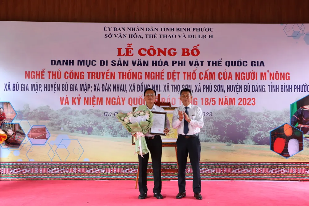 Đại diện Bộ Văn hóa, Thể thao và Du lịch tại TPHCM trao quyết định và tặng hoa chúc mừng huyện Bù Đăng