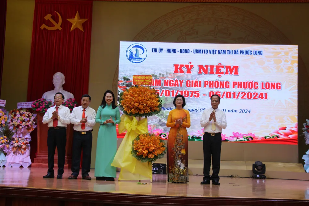 Lãnh đạo tỉnh Bình Phước (bên phải) tặng lẵng hoa chúc mừng tại buổi họp mặt kỷ niệm