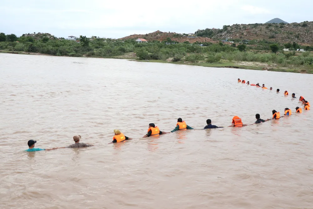 Người dân, lực lượng chức năng cùng đan tay nhau, dầm mình trong nước dò tìm tung tích của em học sinh lớp 6