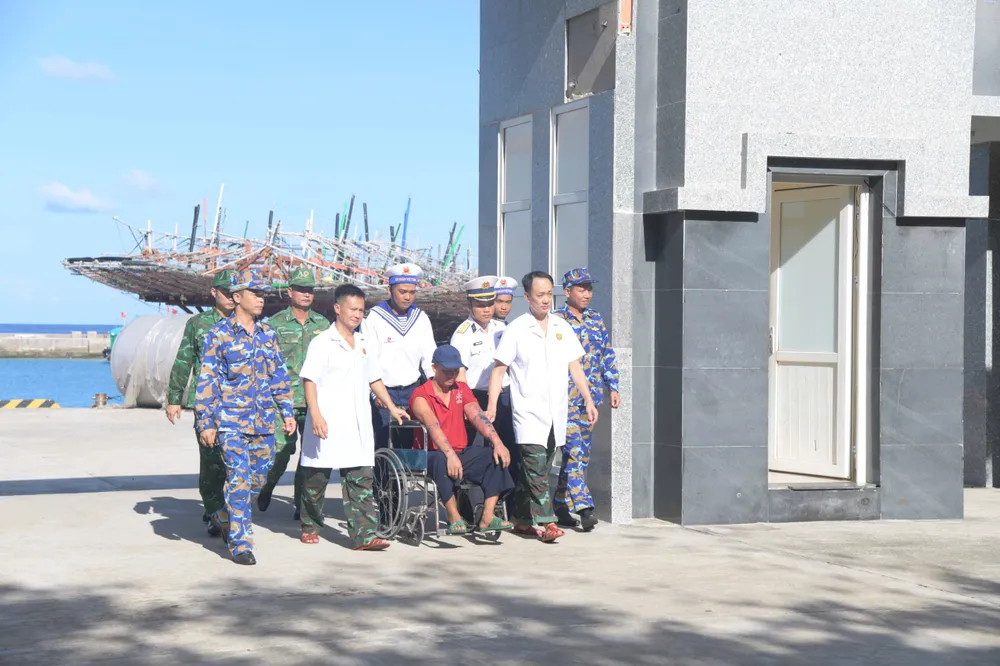 Ngư dân khẩn trương được di chuyển đến bệnh xá đảo để cấp cứu.jpg
