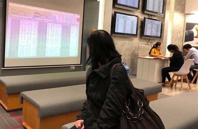 An investor follows transactions at Saigon Securities Inc (SSI) in Hanoi (Photo: VNS)
