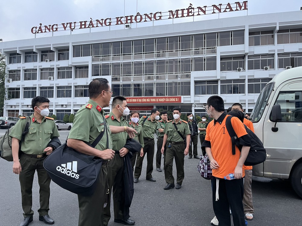 Functional forces are deporting the 12 illegally-intruding foreigners (orange T-shirts) (Photo: Chi Thach)