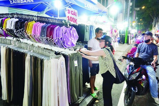 Sidewalk encroachment for clothing sale in Nguyen Trai Street, Ward 3, District 5, Ho Chi Minh City in the evening of July 11. (Photo: SGGP)