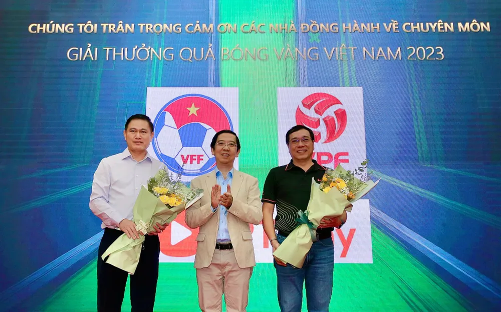 Trưởng Ban tổ chức tặng hoa ông Trần Anh Tú - Phó Chủ tịch VFF (bìa trái) và ông Đinh Quang Tuấn - Giám đốc Quản trị FPT Play (bìa phải) - là hai đại diện nhà đồng hành chuyên môn của giải thưởng năm nay